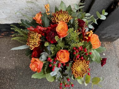 Wild Ember Christmas bouquet against a white and grey background.